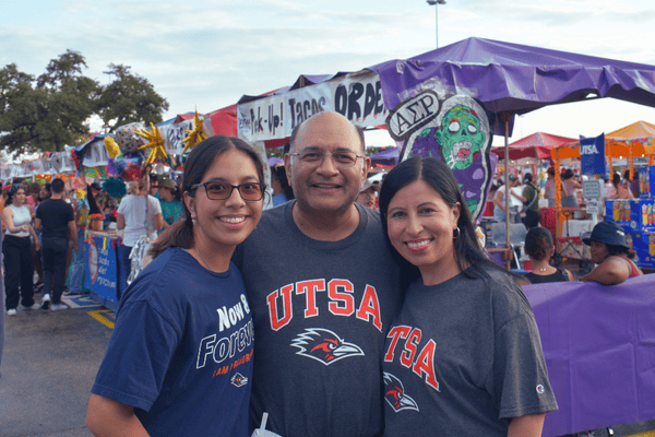 family in front of a row of booths at BestFest